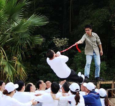 干部在進(jìn)行拓展器材-信任背摔項目中